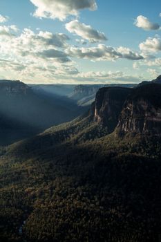 Stunning aerial view of Blue Mountains canyon, Leura, NSW, Australia, framed by dramatic clouds.