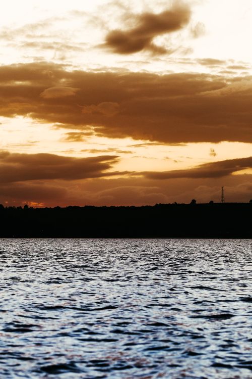 Free Dramatic sunset sky over a tranquil lake creates a serene and peaceful atmosphere. Stock Photo
