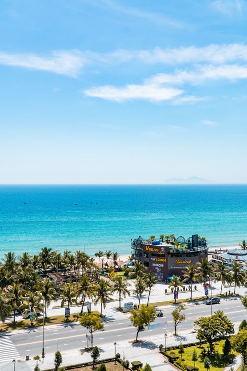 Free A stunning aerial view of a tropical beach with palm trees and a clear blue ocean. Stock Photo