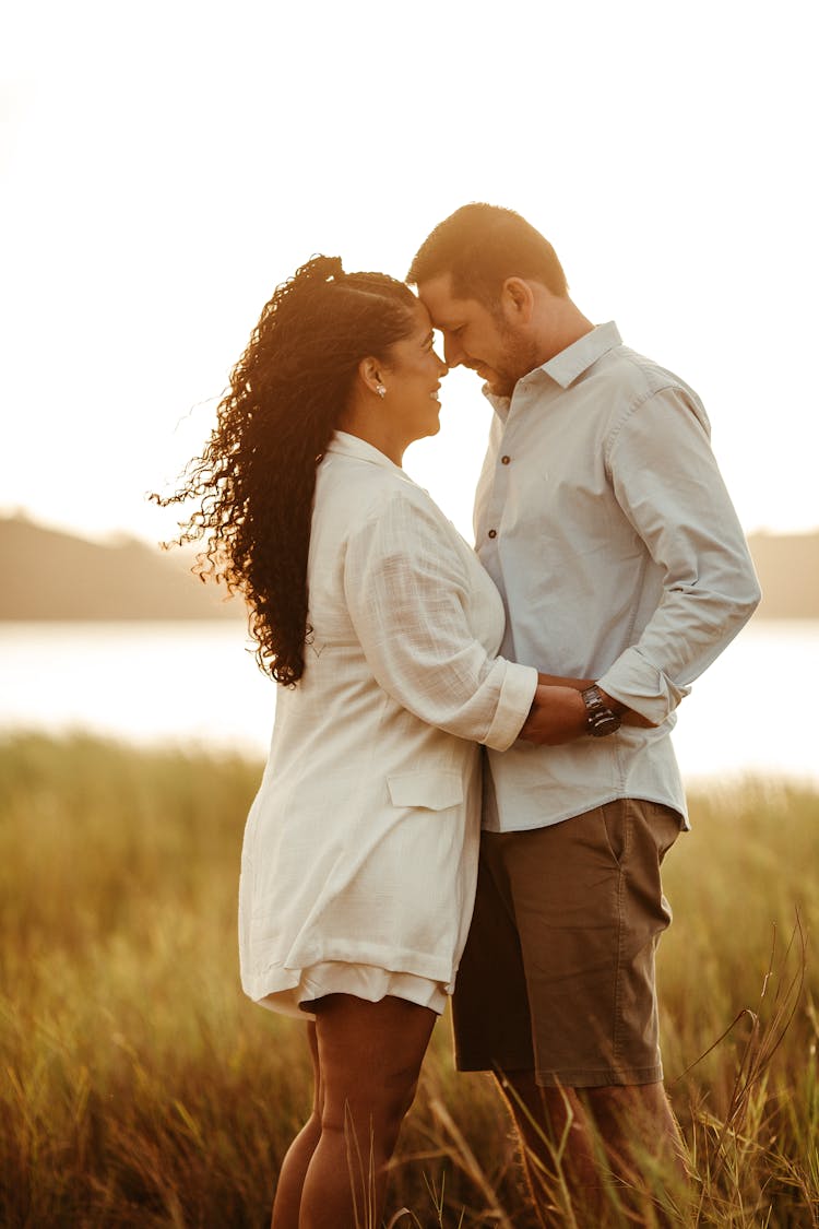 Happy Couple Hugging In Field On Sunset