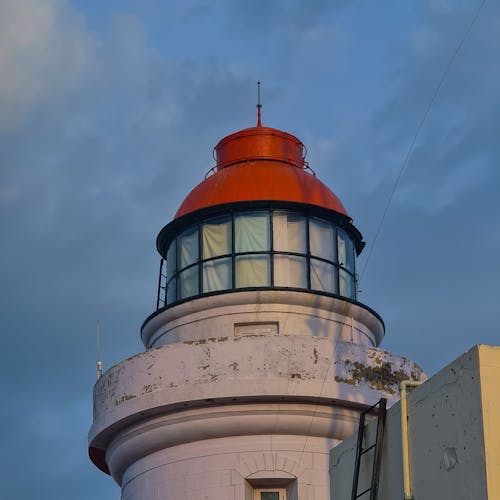 White and Red Concrete Lighthouse Under Blue Sky