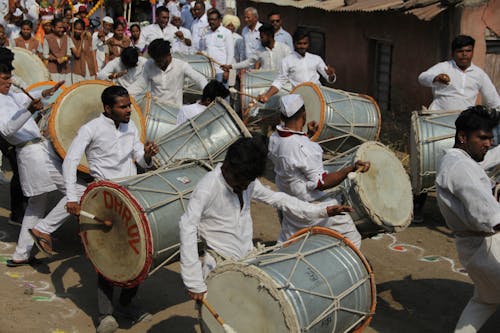 Men in White Dress Shirt Playing Drums in a Parade