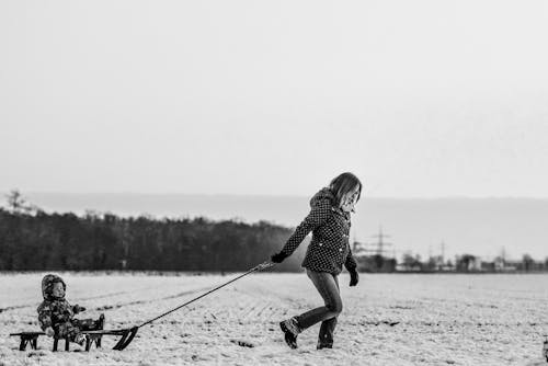 Woman Pulling Snow Sled With Baby