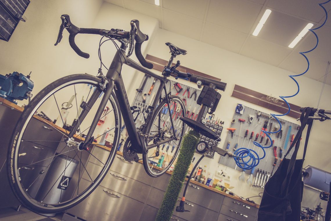 Road bicycle positioned inside a modern repair workshop with maintenance tools