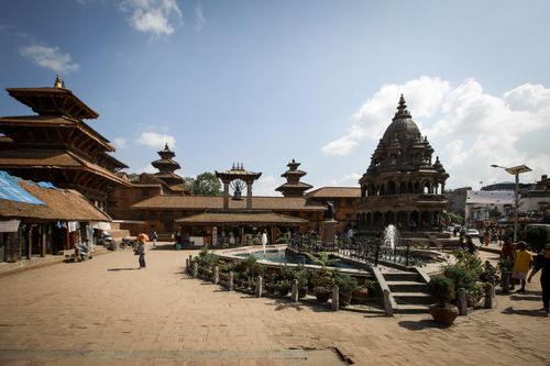 Free Scenic view of Patan Durbar Square with temples and tourists. Sunny day. Stock Photo