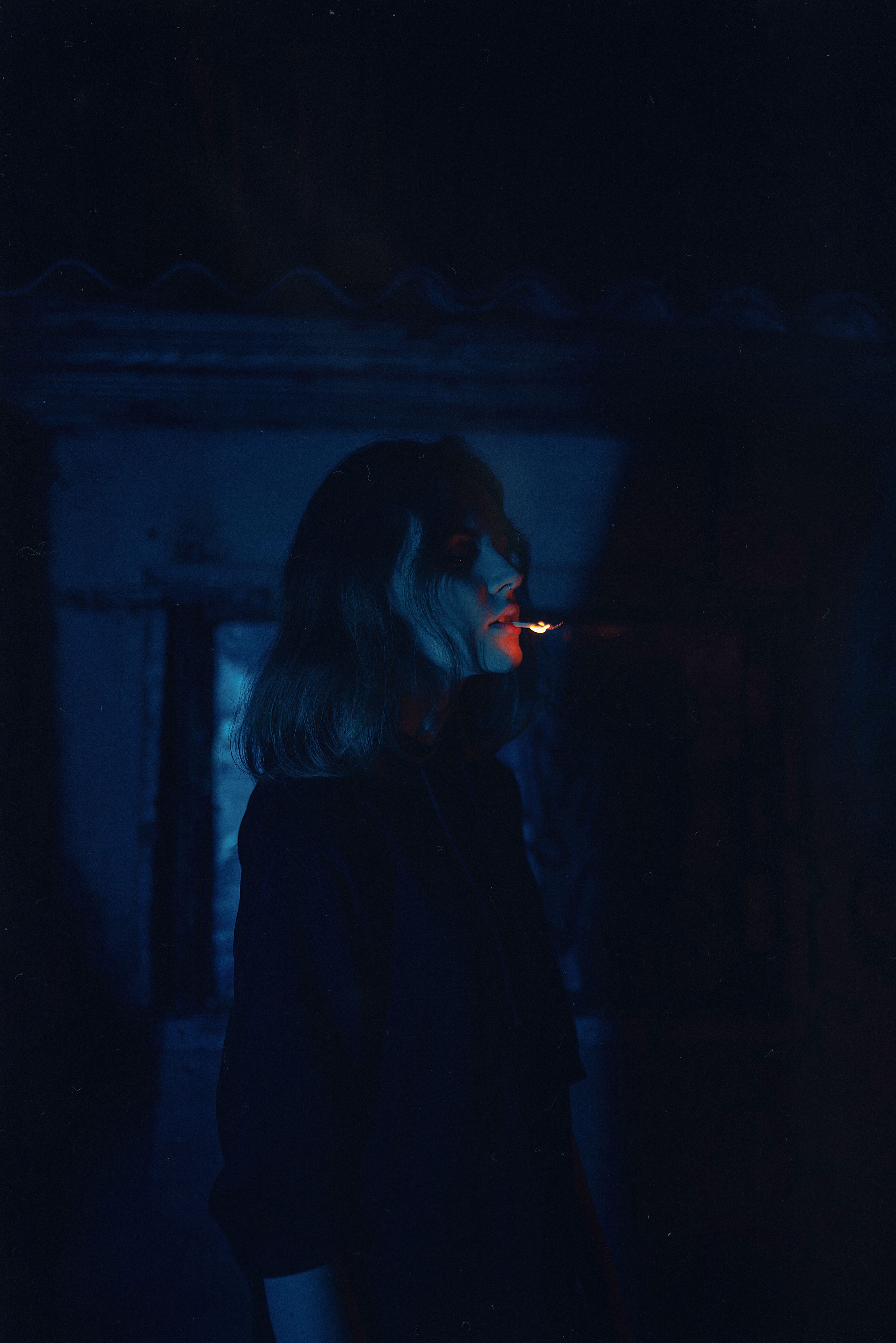 A Woman Standing in the Dark Room while Looking Afar · Free Stock Photo