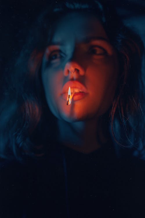 Woman with Lighted Match Stick on Her Mouth