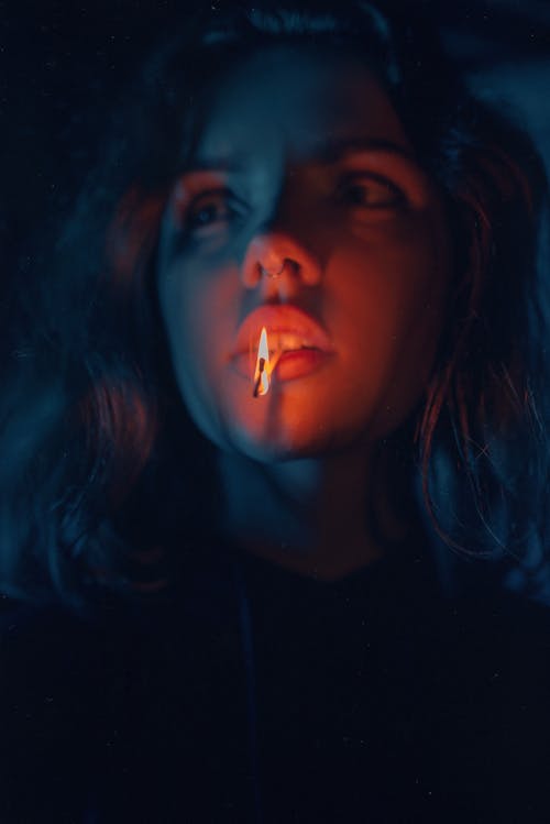 Woman with Lighted Match Stick on Her Mouth