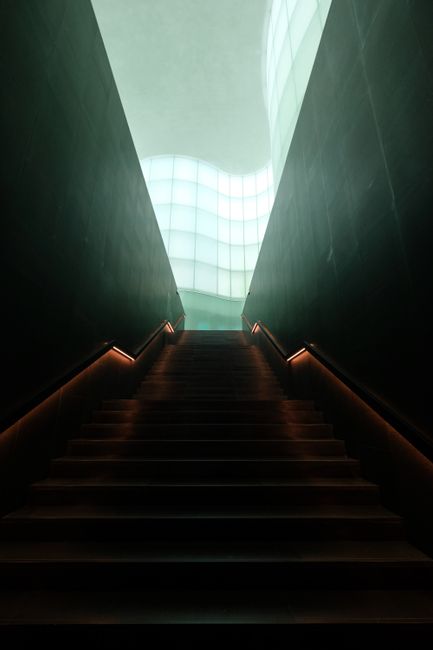 A modern staircase with minimalist design and atmospheric lighting creating a futuristic ambiance.