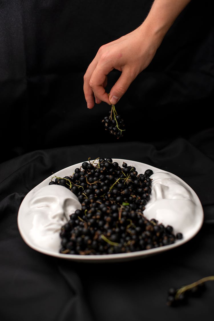 Hand Holding Fruit Over Tray With Faces