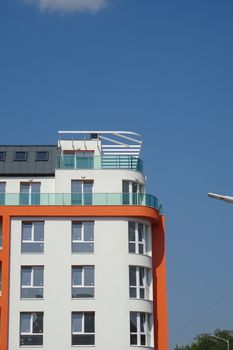Contemporary apartment building against a clear blue sky. Ideal for urban architecture concepts.