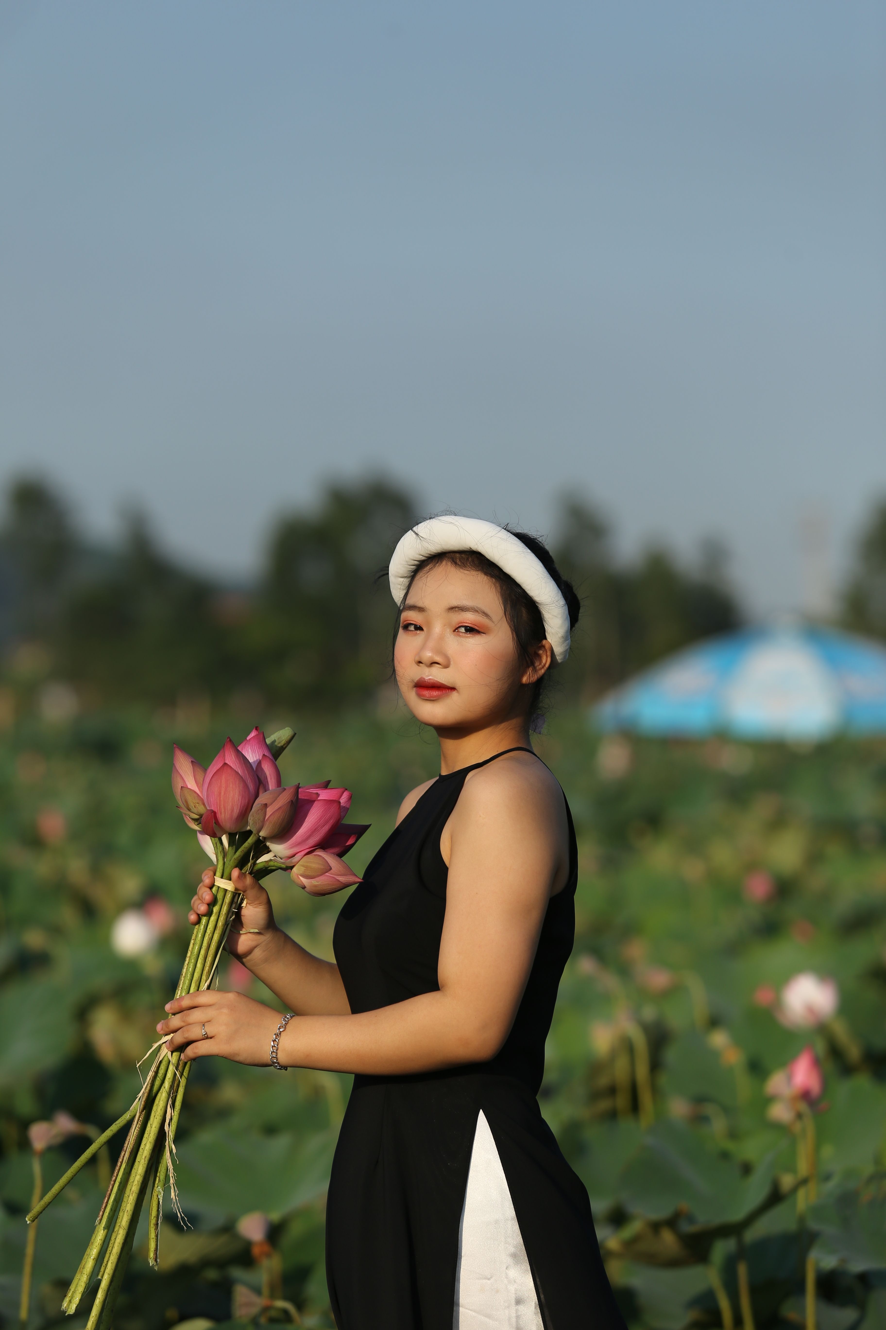Woman in Black Dress Holding Flowers · Free Stock Photo
