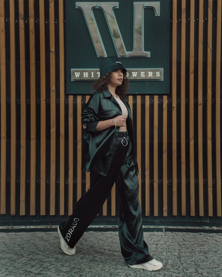 Young Woman In Fashion Trends Posing On A Wall Signage