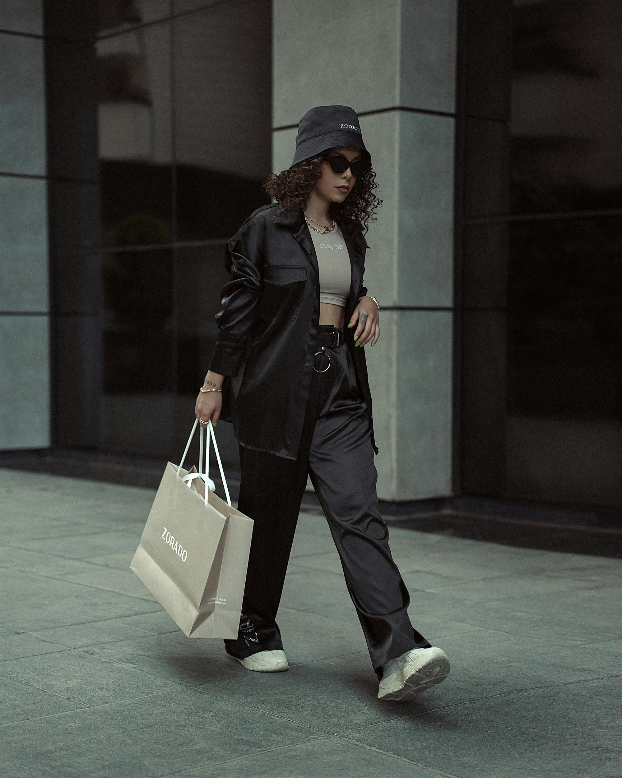 stylish woman walking street with shopping bag