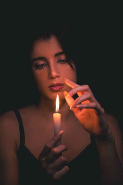 Portrait of a woman holding a candle, photo by RedWolf on Pexels