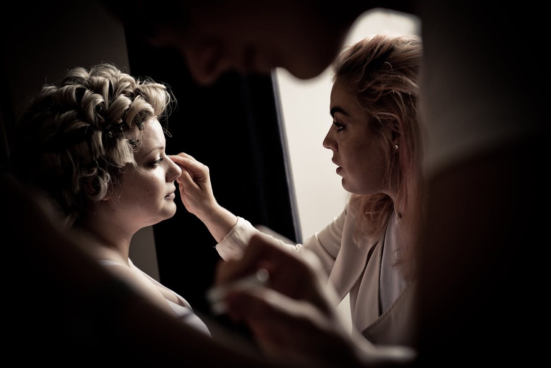 Free Person Putting Makeup On Woman Stock Photo