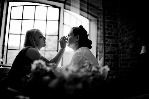 Grayscale Photo Of Two Women Facing Each Other