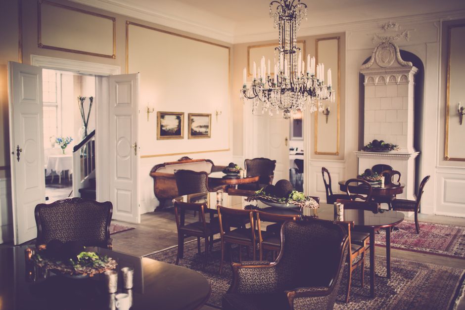 Elegant living room featuring a navy blue accent wall, a gold-framed mirror, and warm gold lighting fixtures