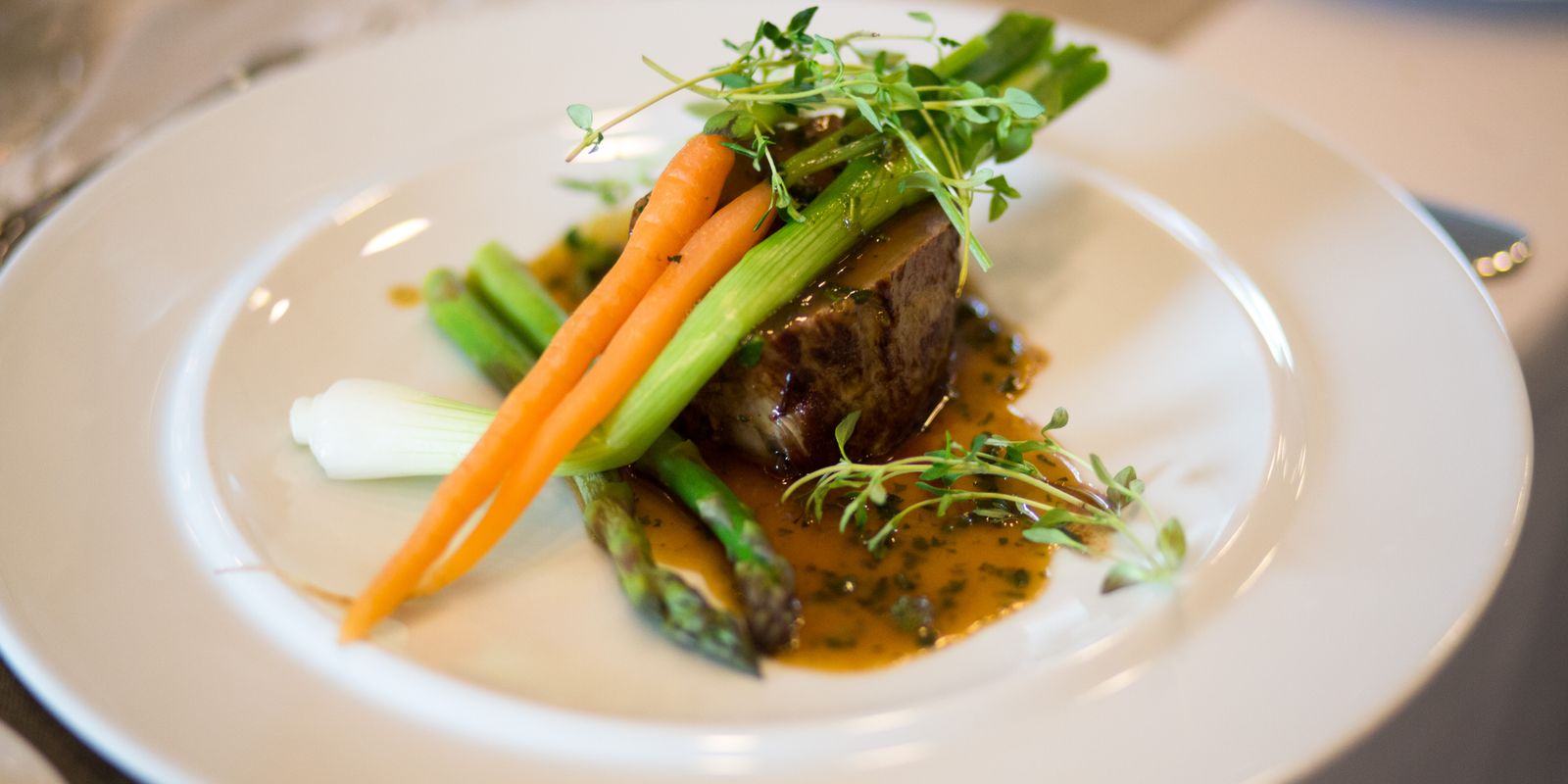 A luxurious gourmet meal elegantly plated with vegetables and sauce
