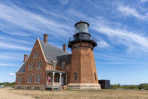 Red Brick Lighthouse Under White Clouds