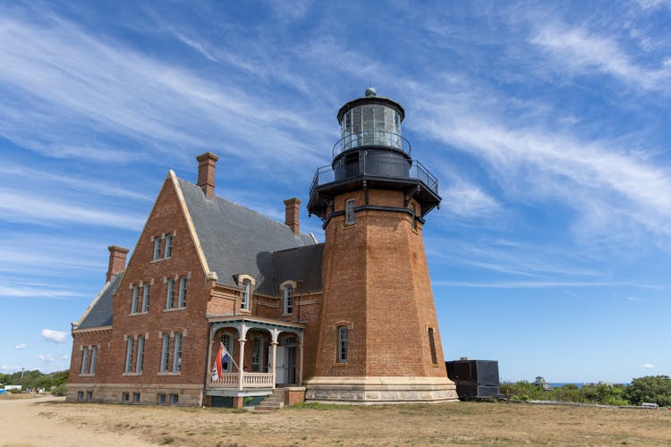 Red Brick Lighthouse Under White Clouds