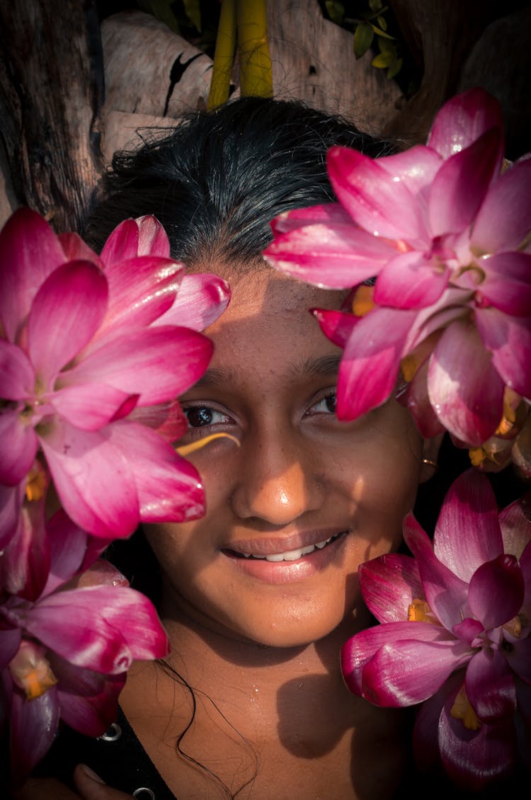 Close-Up Photo Of A Woman Covering Face With Pink Sacred Lotus Flowers