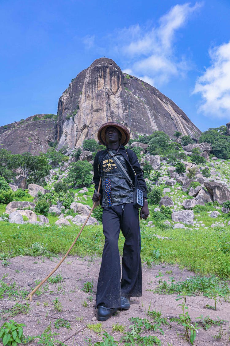 Man Wearing Black Pants Holding A Long Stick