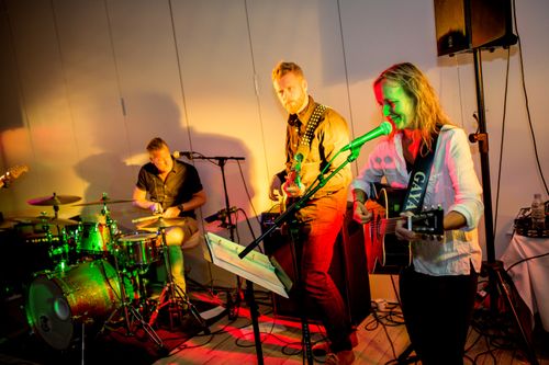 Free Lively band performing with guitars and drums under colorful stage lights. Stock Photo