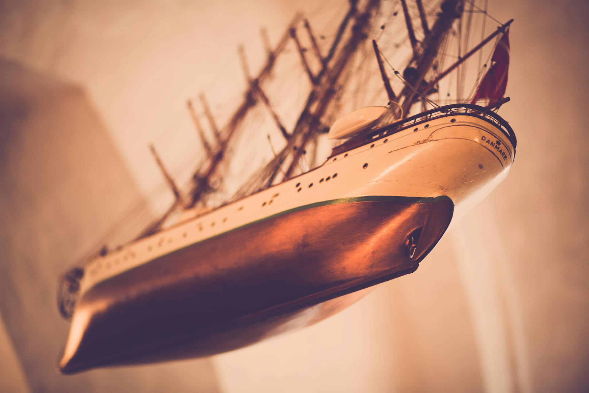 Low angle view of a vintage ship model with a soft, warm focus.