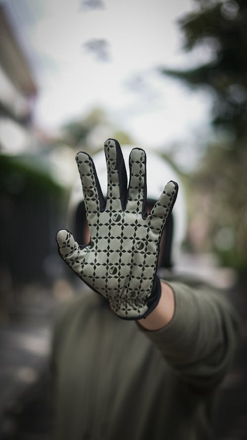 Close-Up Photo of a Person Wearing and Showing Sport Gloves on Hand