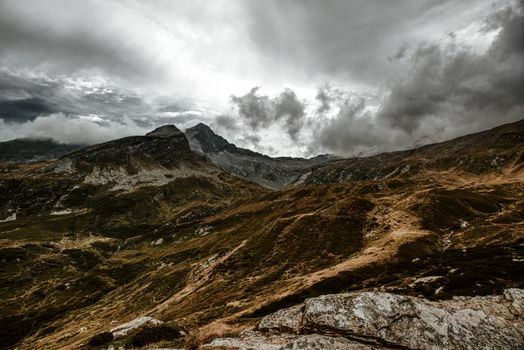 Breathtaking mountain range under a dramatic cloudy sky showcasing rugged terrain and natural beauty.