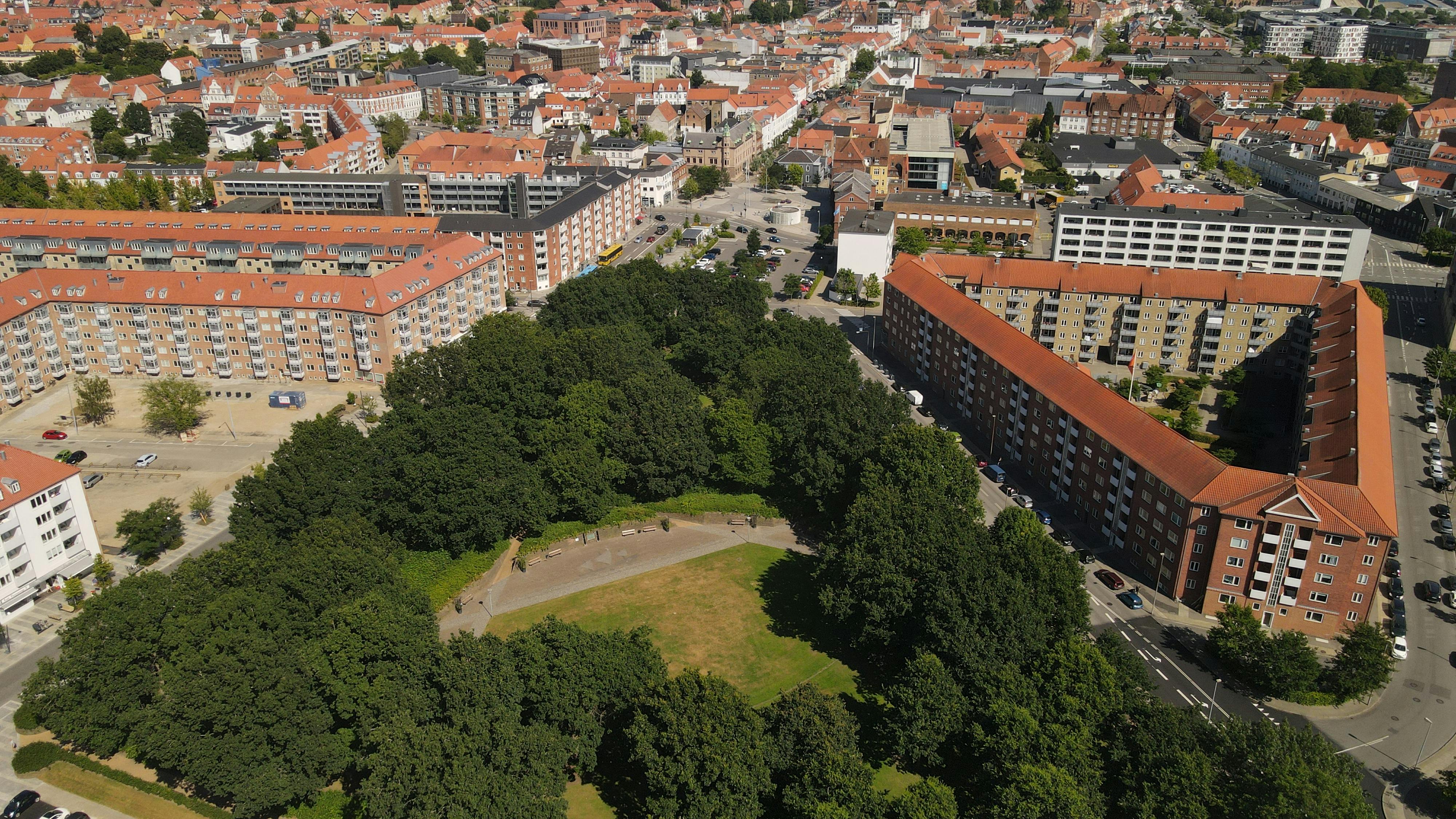 A vibrant aerial shot of Horsens, Denmark, showcasing urban architecture and lush greenery.