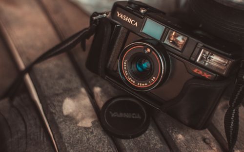 Free Close-up of a classic Yashica camera highlighting its vintage charm on a rustic wooden background. Stock Photo