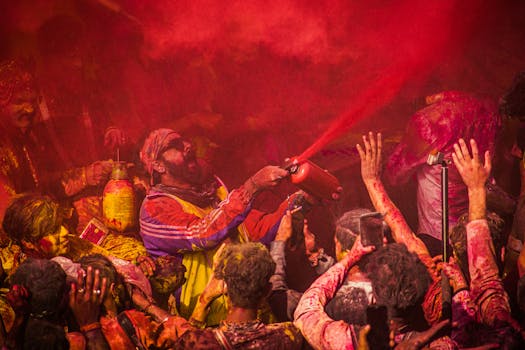 Crowd celebrating Holi with vivid colors and joy, embracing Indian culture.