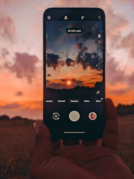 A smartphone capturing a stunning sunset scene, blending technology with nature.