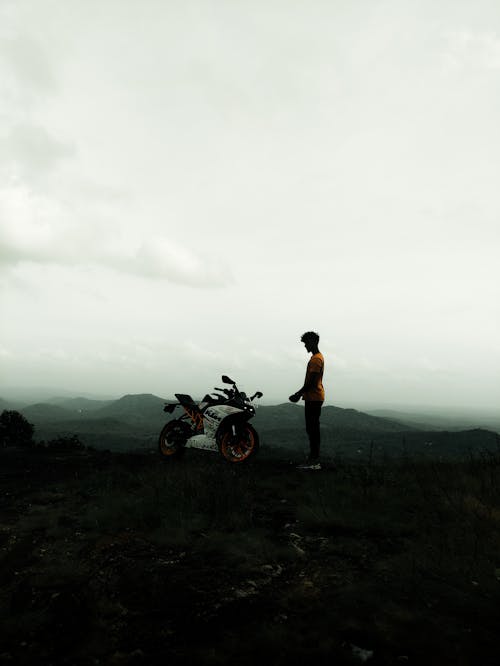 A Man Standing Beside the Motorcycle