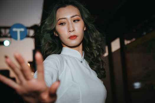 A Woman in Curly Hair Wearing White Ao Dai Standing while Looking Afar