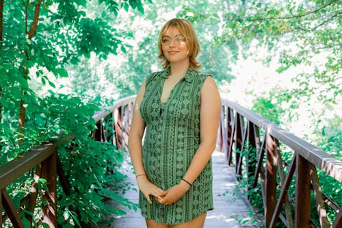 Free Woman in Gray Sleeveless Dress Standing on Wooden Bridge Stock Photo
