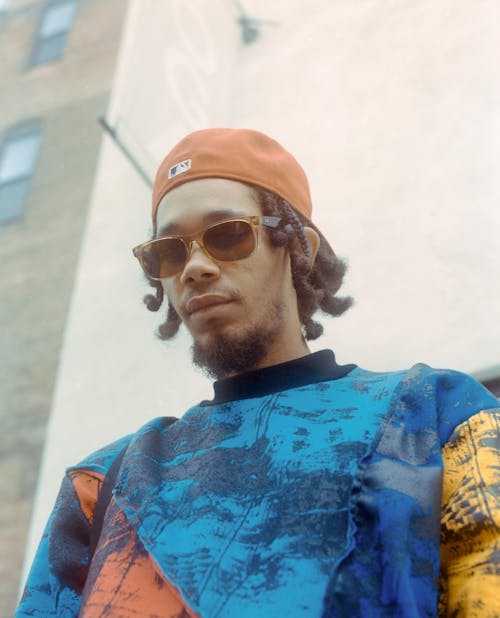 Low Angle View Portrait of a Young Man Wearing Sunglasses and His Cap Backwards 