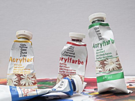 Close-up of colorful acrylic paint tubes on a canvas, ideal for arts and crafts projects.
