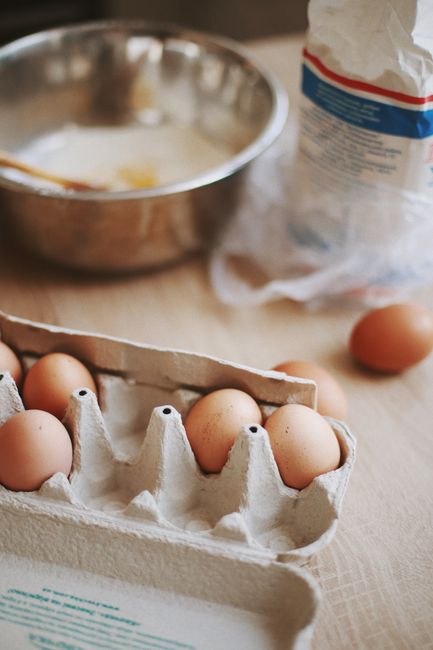 Close-up of eggs, flour, and mixing bowl in kitchen setup for baking.