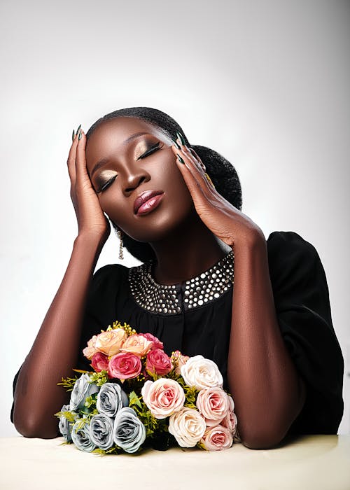 A Beautiful Woman Touching Her Head while Posing at the Camera