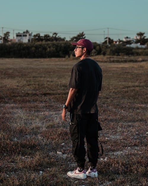 A Man in Black Clothing Standing on Grass