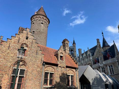 Explore the stunning brick architecture of the Gruuthusemuseum in Bruges, Belgium under a bright blue sky.
