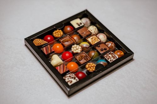 Free A delightful assortment of gourmet pralines and chocolates in a stylish box, perfect for gifting. Stock Photo