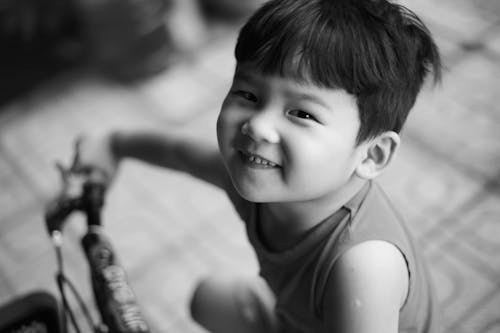 Grayscale Photo of a Kid Smiling
