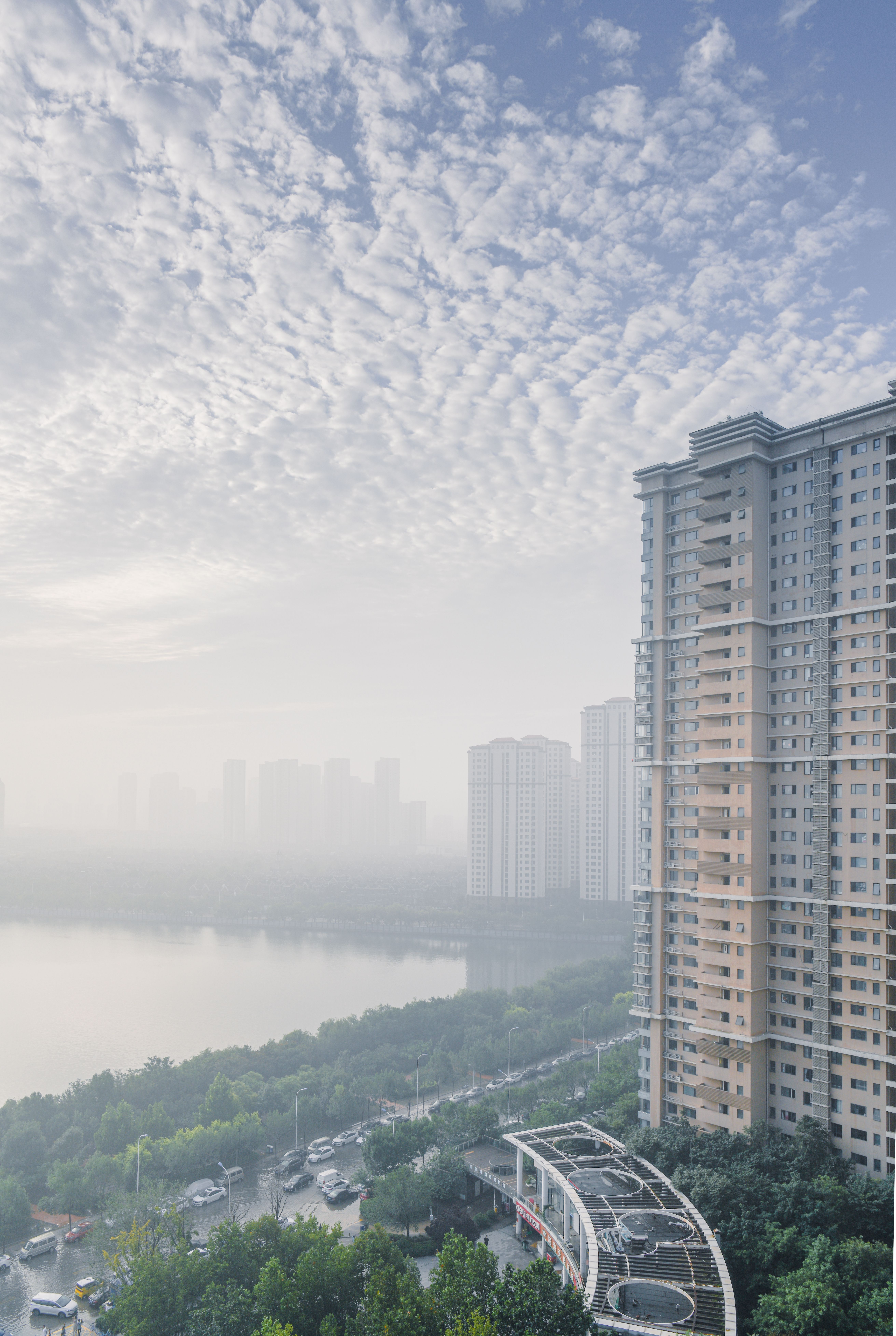 High Rise Buildings In Front of a Bay Under Cloudy Sky · Free Stock Photo
