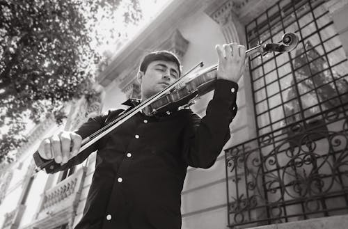 Black and White Photo of a Man Playing Violin