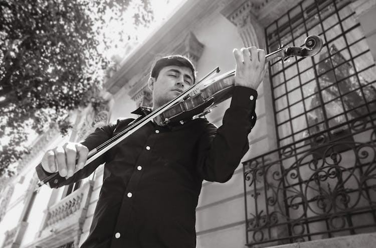 Black And White Photo Of A Man Playing Violin