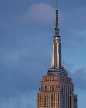 The iconic Empire State Building in New York City stands tall against a blue sky.